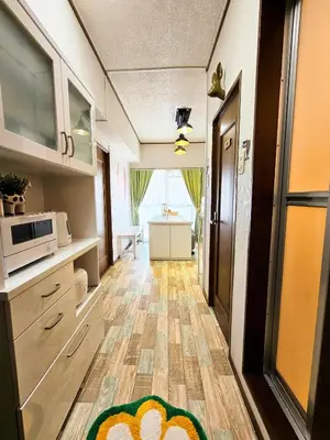 a room with a kitchen with a microwave and a door at 703. Disneyland, direct bus to the airport/1minute's walk from the station. in Tokyo