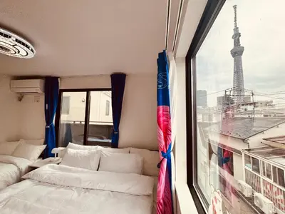 a room with two beds and a window with the eiffel tower at Colorful House SKY TREE in Tokyo