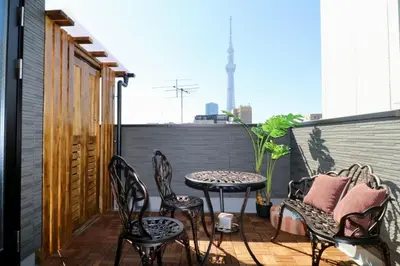 a patio with chairs and a table on a balcony at Sky Terrace \u65b0\u7bc9\u72ec\u680b\u6238\u5efa \u9633\u5149\u9732\u53f0\u89c2\u666f\u5929\u7a7a\u6811 in Tokyo