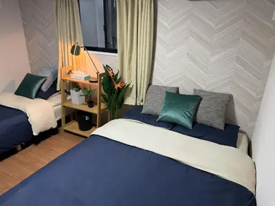 a bedroom with a blue and white bed and a window at Sky Terrace \u65b0\u7bc9\u72ec\u680b\u6238\u5efa \u9633\u5149\u9732\u53f0\u89c2\u666f\u5929\u7a7a\u6811 in Tokyo