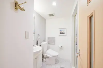 a white bathroom with a toilet and a sink at Shinjuku Kabukicho Designer's Apartment III in Tokyo