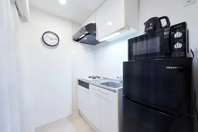 a kitchen with a black refrigerator and a sink at Shinjuku Kabukicho Designer's Apartment III in Tokyo
