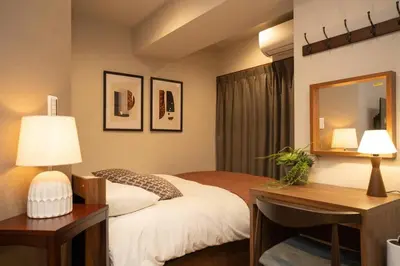 a bedroom with a bed and a desk and a mirror at \u30a2\u30f3\u30c9\u30b9\u30c6\u30a4\u65b0\u5bbf7\u4e01\u76ee in Tokyo