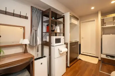 a small kitchen with a refrigerator and a microwave at \u30a2\u30f3\u30c9\u30b9\u30c6\u30a4\u65b0\u5bbf7\u4e01\u76ee in Tokyo