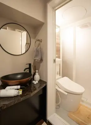 a bathroom with a sink and a toilet and a mirror at \u30a2\u30f3\u30c9\u30b9\u30c6\u30a4\u65b0\u5bbf7\u4e01\u76ee in Tokyo