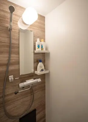 a bathroom with a shower with a mirror and a sink at \u30a2\u30f3\u30c9\u30b9\u30c6\u30a4\u65b0\u5bbf7\u4e01\u76ee in Tokyo