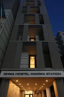 a building with a sign that reads uhma hospital minerva station at OHWA hostel minowa station in Tokyo