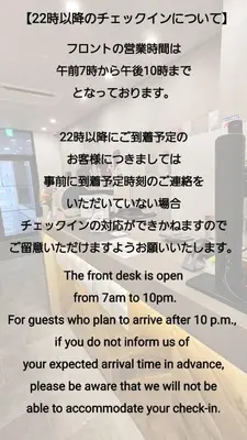 a sign that reads the front desk is open from to at OHWA hostel minowa station in Tokyo