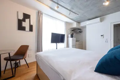 a bedroom with a bed and a chair and a window at Lega land\u4e09\u8ed2\u8336\u5c4bANNEX in Tokyo