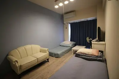 a living room with a couch and a chair at \u3010 \u30c7\u30a3\u30ba\u30cb\u30fc\u3078\u697d\u3061\u3093\u306a\u90e8\u5c4b\u3011\u8eca\u306711\u5206\uff0a\u30b3\u30f3\u30d3\u30cb\u3042\u308a\uff01\u6771\u4eac\u30e1\u30c8\u30ed\u845b\u897f\u99c5\u304b\u3089\u5f92\u6b695\u5206\uff01 in Tokyo