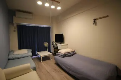 a bedroom with two beds and a desk with a tv at \u3010 \u30c7\u30a3\u30ba\u30cb\u30fc\u3078\u697d\u3061\u3093\u306a\u90e8\u5c4b\u3011\u8eca\u306711\u5206\uff0a\u30b3\u30f3\u30d3\u30cb\u3042\u308a\uff01\u6771\u4eac\u30e1\u30c8\u30ed\u845b\u897f\u99c5\u304b\u3089\u5f92\u6b695\u5206\uff01 in Tokyo