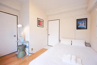 a bedroom with a large white bed with white pillows at Mi-FUJITAKI WASEDA in Tokyo