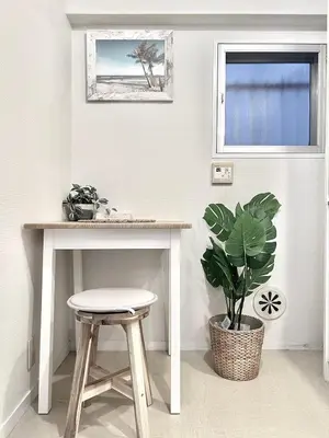 a table and stool in a room with a plant at Mi-FUJITAKI WASEDA in Tokyo