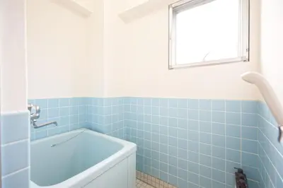 a blue tiled bathroom with a tub and a window at Mi-FUJITAKI WASEDA in Tokyo