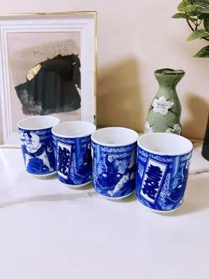 four blue and white cups sitting on a shelf with a vase at 交通便利 山手線池袋駅 徒歩6分 東池袋駅徒歩3分 2~5人 エレベーター WIFI 新宿/渋谷/銀座/築地/浅草/原宿近い！ in Tokyo