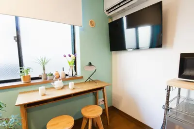 a small kitchen with a table and two stools at East Court Nagasaki - Vacation STAY 13035 in Tokyo