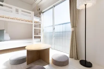 a bedroom with bunk beds and a table and a stool at 