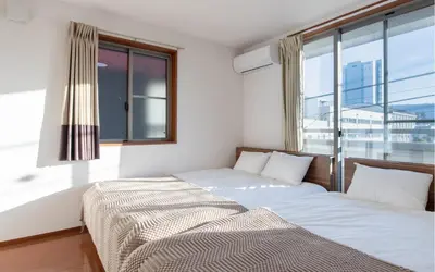 two beds in a room with a large window at Residential Voyan Minamisunacho - Vacation STAY 14988v in Tokyo