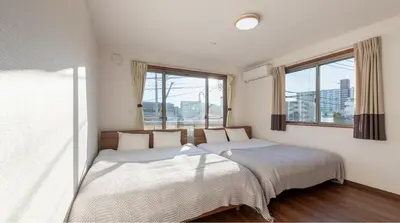 two beds in a room with two windows at Residential Voyan Minamisunacho - Vacation STAY 14988v in Tokyo