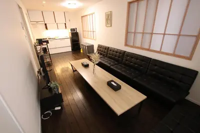 a living room with a black couch and a table at \u5357\u6c60\u888b\u6238\u5efa in Tokyo
