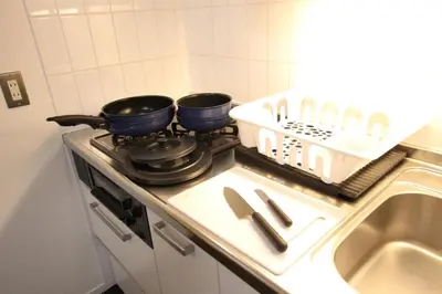 two pans sitting on top of a stove in a kitchen at \u5357\u6c60\u888b\u6238\u5efa in Tokyo
