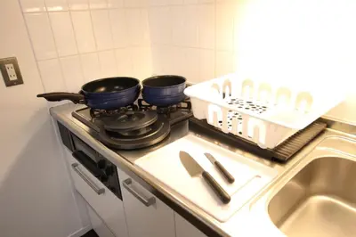 two pans sitting on top of a stove in a kitchen at \u5357\u6c60\u888b\u6238\u5efa in Tokyo