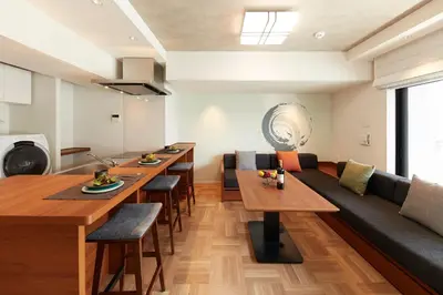 a living room with wooden tables and a couch at MONday Apart Premium Asakusa in Tokyo