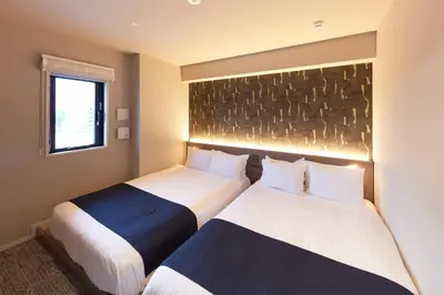 two beds sitting next to each other in a room at MONday Apart Premium Asakusa in Tokyo