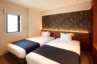 a hotel room with two beds and a stone wall at MONday Apart Premium Asakusa in Tokyo