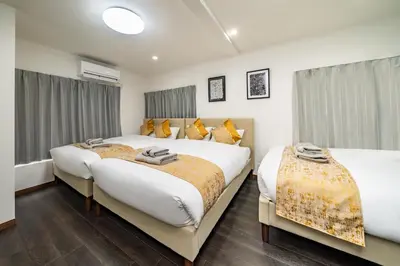 two beds in a hotel room with windows at 87, Senzoku, Detached house for rent, \u5343\u675f in Tokyo