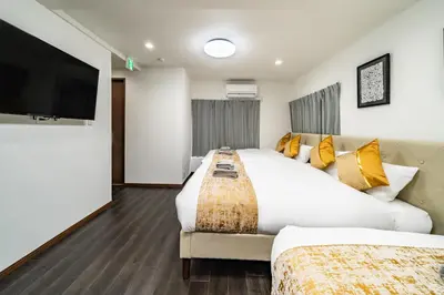 a hotel room with two beds and a flat screen tv at 87, Senzoku, Detached house for rent, \u5343\u675f in Tokyo