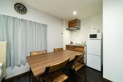 a kitchen with a wooden table and a refrigerator at 87, Senzoku, Detached house for rent, \u5343\u675f in Tokyo