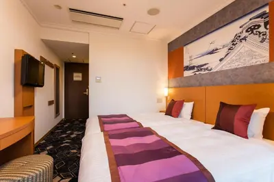 a hotel room with a large bed and a tv at Ryogoku View Hotel in Tokyo