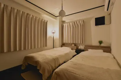 two beds in a room with curtains and a tv at Okada Building - Vacation STAY 16358 in Tokyo
