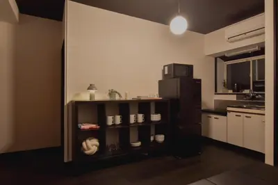 a small kitchen with a black refrigerator and a shelf at Okada Building - Vacation STAY 16358 in Tokyo