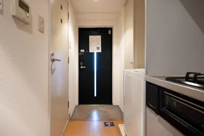 a hallway leading into a kitchen with a black door at \u30b7\u30e3\u30eb\u30de\u30f3\u3084\u3088\u3044 in Tokyo