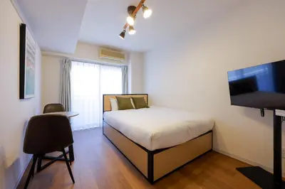 a bedroom with a bed and a flat screen tv at \u30b7\u30e3\u30eb\u30de\u30f3\u3084\u3088\u3044 in Tokyo