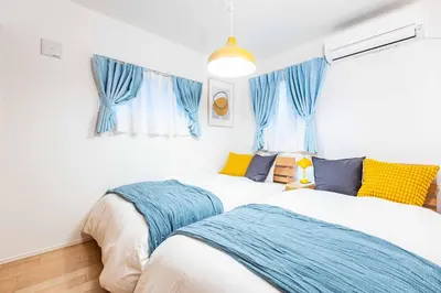 two beds in a room with blue curtains at Modern House Tokyo east in Tokyo