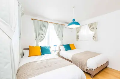 two beds with colorful pillows in a bedroom at Modern House Tokyo east in Tokyo