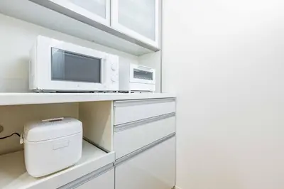 a kitchen with a microwave and a computer on a shelf at Modern House Tokyo east in Tokyo