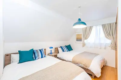 a bedroom with two beds and a window at Modern House Tokyo east in Tokyo
