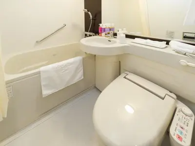 a bathroom with a toilet and a sink at Sotetsu Fresa Inn Ochanomizu Jimbocho in Tokyo