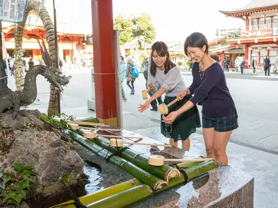 two girls are standing next to a water fountain at Sotetsu Fresa Inn Ochanomizu Jimbocho in Tokyo