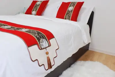a white bed with a red and white comforter at \u5409\u5c4b in Tokyo