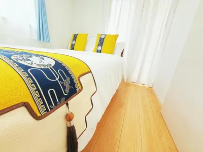 a bedroom with a bed with a yellow and blue blanket at \u5409\u5c4b in Tokyo