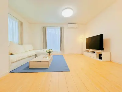 a living room with a white couch and a flat screen tv at \u5409\u5c4b in Tokyo