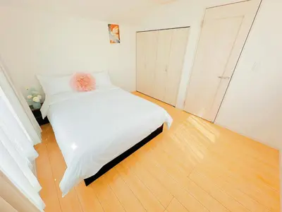 a bedroom with a white bed and a wooden floor at \u5409\u5c4b in Tokyo