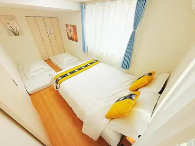 a small bedroom with two beds with yellow pillows at \u5409\u5c4b in Tokyo