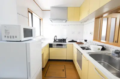 a white kitchen with a sink and a microwave at Sui HOUSE \u5317\u8d64\u7fbd in Tokyo