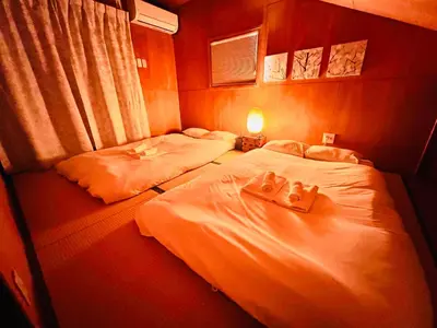two beds in a hotel room with towels on them at Sui HOUSE \u5317\u8d64\u7fbd in Tokyo